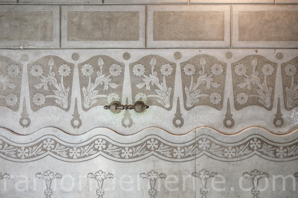 Relieves con motivos florales en la pared de una porteria del Eixample de Barcelona