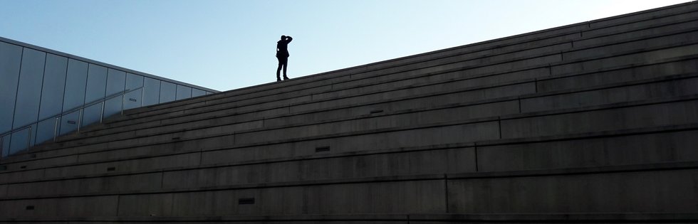 Ramon sobre las escaleras frente a la Torre Agbar fotografiando el atardecer tras el mercat dels Encants de Barcelona.